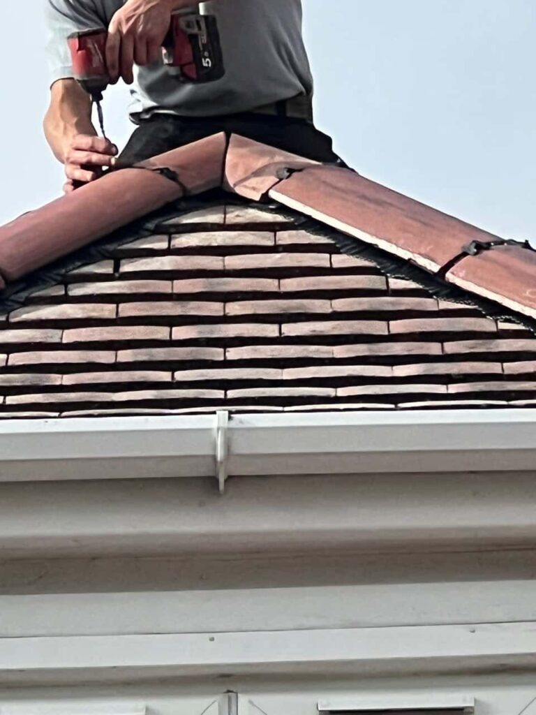 This is a photo of one of the operatives of Brownsover Roofing Repairs installing new ridge tiles